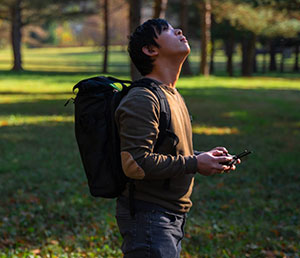 Grant Chenug, outdoors wearing backpack